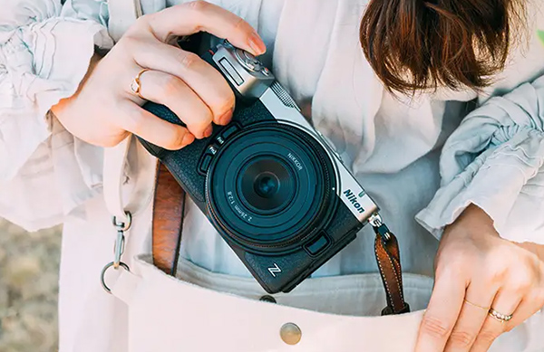 Жінка кладе в сумку Nikon Z5IIC